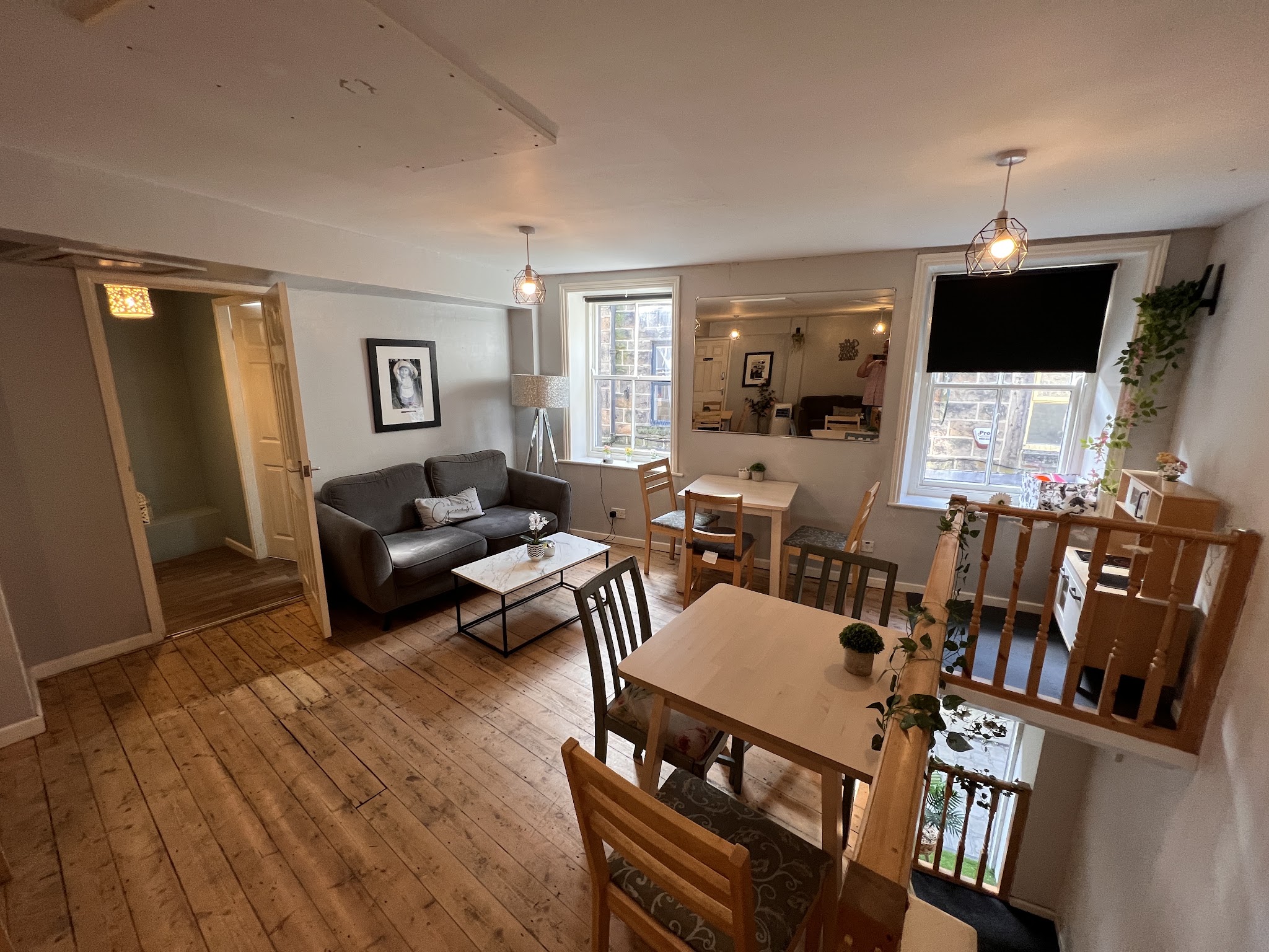 Mondo's upstairs seating with wooden tables, a sofa and windows overlooking Boroughgate